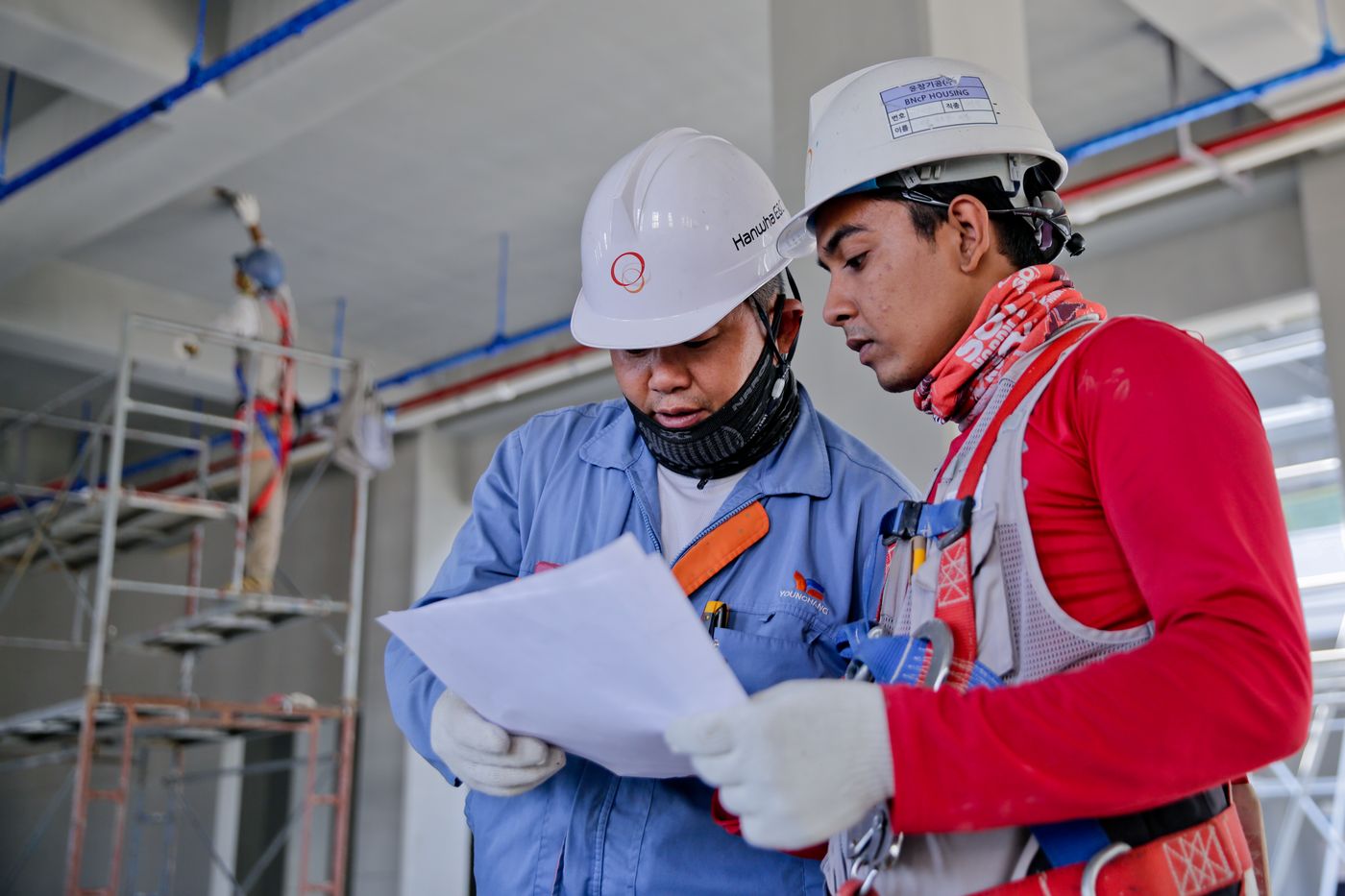 Builders reviewing plans on site — the coordination that keeps a build on schedule